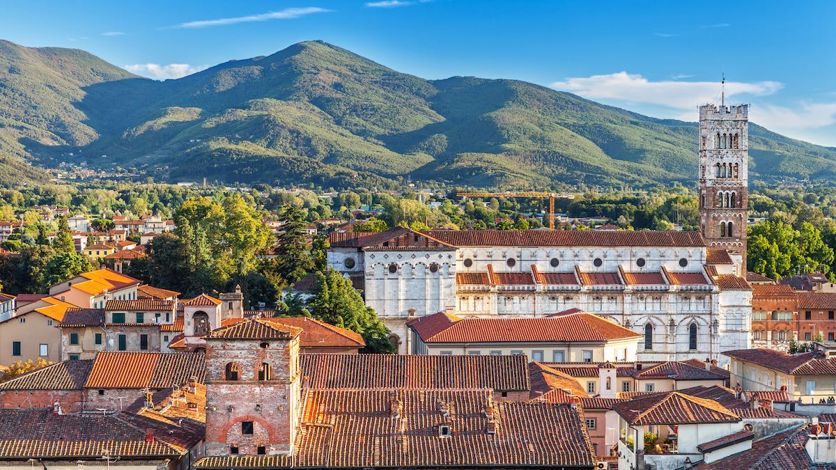 Vivid rooftops of Lucca, Italy, background of colorful, green hills