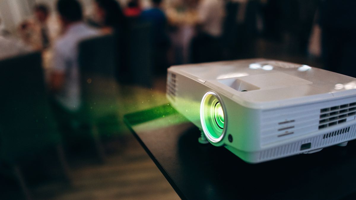 Modern video projector on a tabletop in use during a meeting